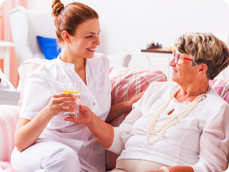 Caregiver giving medicine to elder