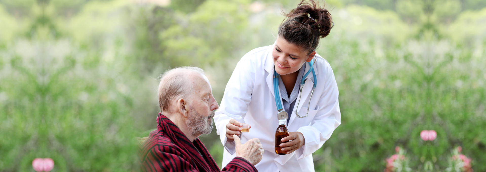Nurse giving medicine to elder