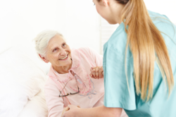 Caregiver assisting a senior in standing up